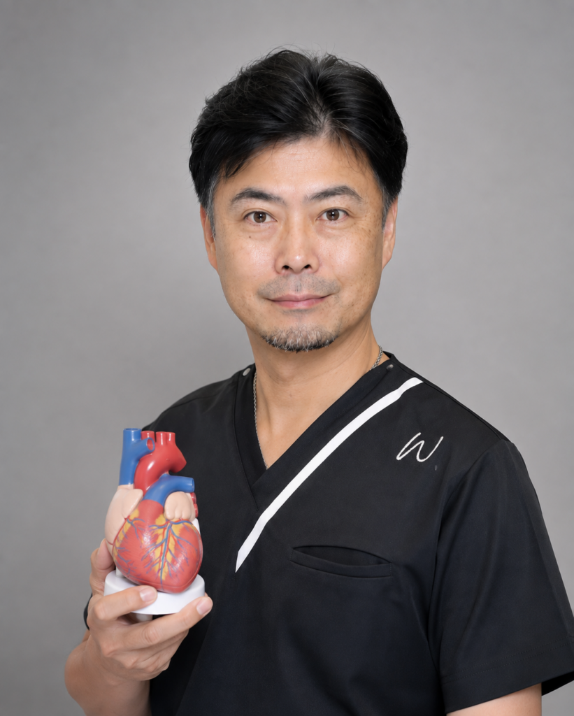 Male healthcare professional in black scrubs holding a detailed 3D heart model.